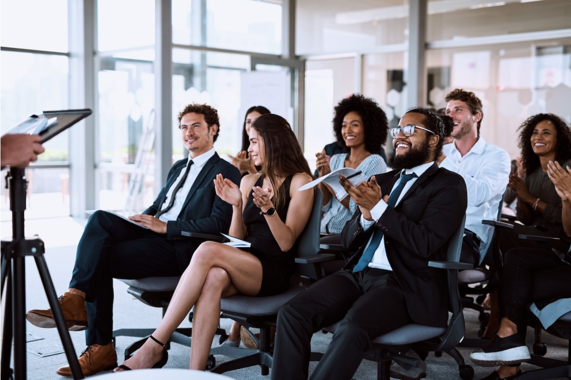 Business professionals applauding during a keynote presentation, engaged audience at a corporate speaking event
